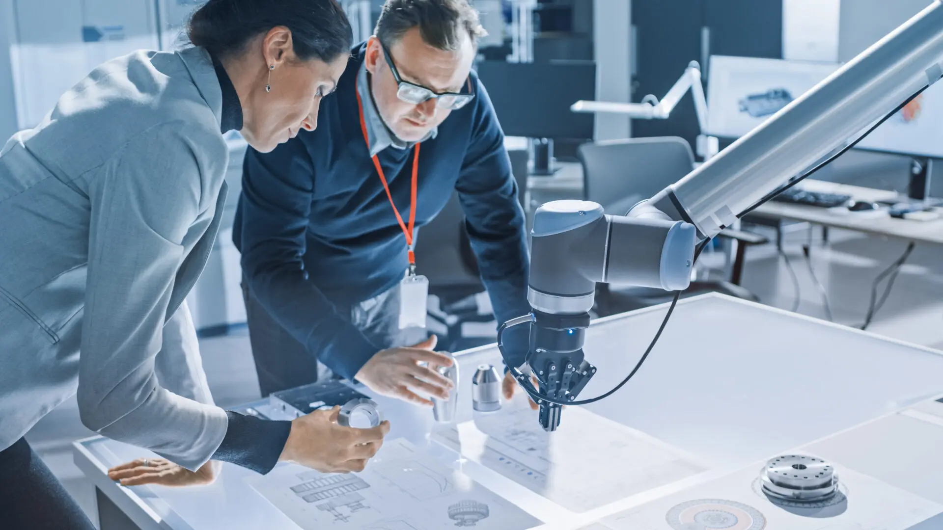 Two people looking at a microscope in an office setting.