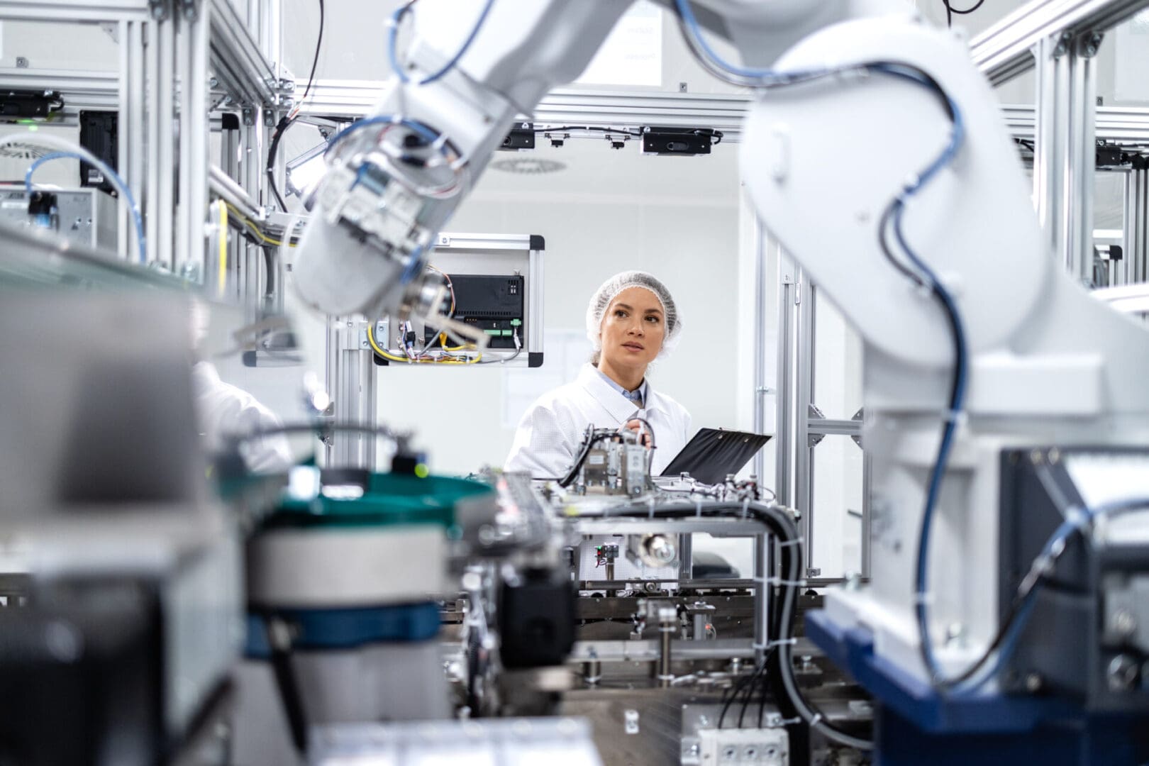 A woman in white lab coat standing next to machine.